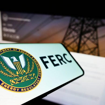 Stuttgart, Germany - 07-24-2022: Mobile phone with logo of American Federal Energy Regulatory Commission (FERC) on screen in front of website. Focus on left of phone display.