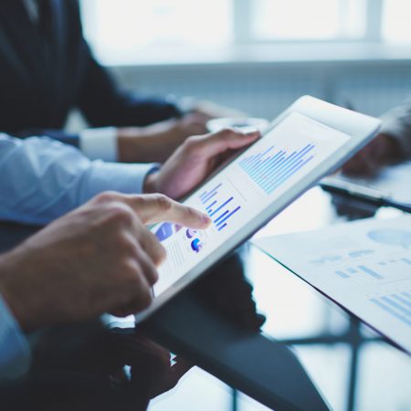 Image of businessperson pointing at document in touchpad at meeting