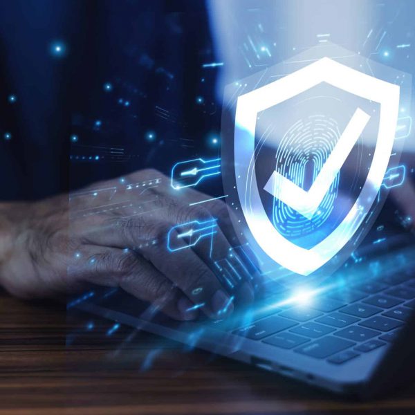Man working on a laptop with advanced cyber security shield, ensuring the protection of sensitive data and securing the digital environment against potential threats. Man working on a laptop with advanced cyber security shield, ensuring the protection of sensitive data and securing the digital environment against potential threats.