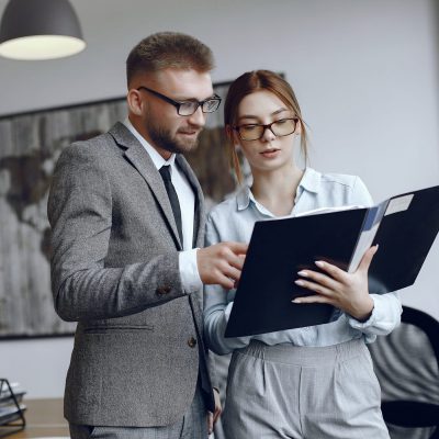 Man and woman read a business contract Woman with glasses.Businessman with documents.Colleagues work together