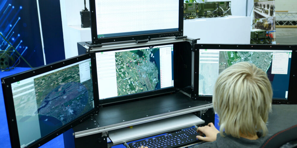 Person reviewing maps on multiple monitors, illustrating Zirous’s blog about AI agents for business.